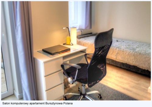 a bedroom with a desk with a chair and a laptop at Dom z ogrodem Bursztynowa Polana in Ustka