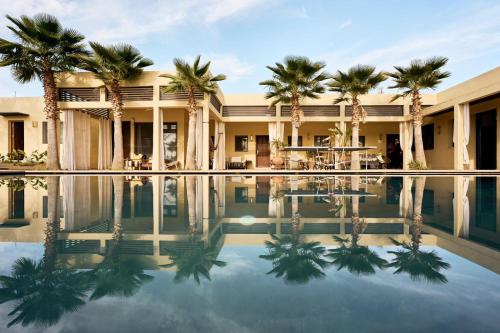 een hotel met palmbomen en een zwembad bij Dar Meha in Marrakesh