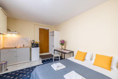 um quarto com uma cama com almofadas amarelas e uma cozinha em argonne gare du midi 29 em Bruxelas