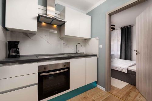 a kitchen with white cabinets and a sink and a bed at Apartment in Silo/Insel Krk 13445 in Šilo