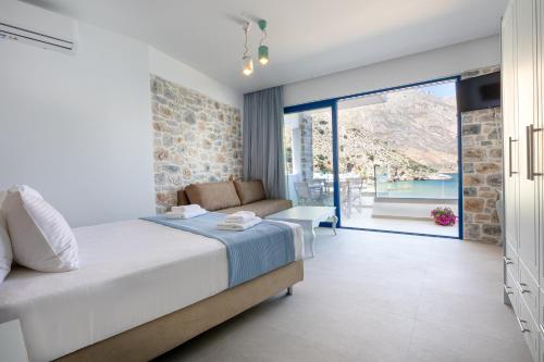 a bedroom with a bed and a large window at Molos Apartments in Loutro
