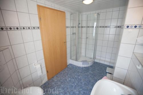 ein Bad mit einer Dusche und einem WC. in der Unterkunft Gästehaus Heidehof in Soltau