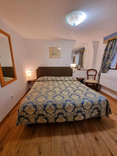 a bedroom with a bed with a blue blanket on it at Albergo Casa Peron in Venice