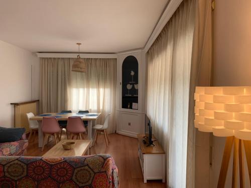 a living room with a table and a dining room at ATICO PLANAS céntrico frente mar in Salou