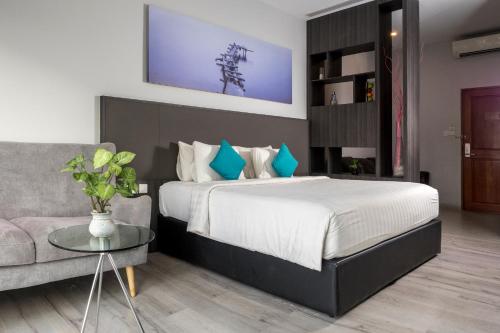 a bedroom with a large bed and a couch at The Hills Batam in Nagoya