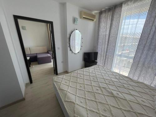 a bedroom with a bed and a large window at Blue Horizon Sarafovo in Burgas City