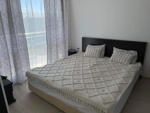 a bedroom with a large bed with a large window at Blue Horizon Sarafovo in Burgas City