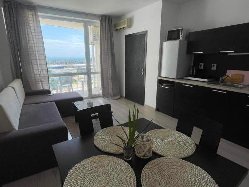 a living room with a table and chairs and a kitchen at Blue Horizon Sarafovo in Burgas City