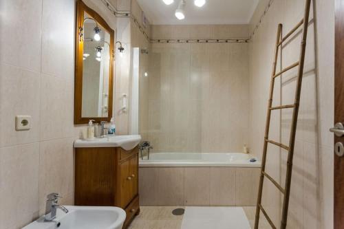a bathroom with a sink and a bath tub at 480 Liberdade Apartamento in Labruge