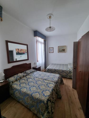 a hotel room with two beds and a window at Albergo Casa Peron in Venice