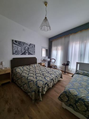 a hotel room with two beds and a window at Albergo Casa Peron in Venice