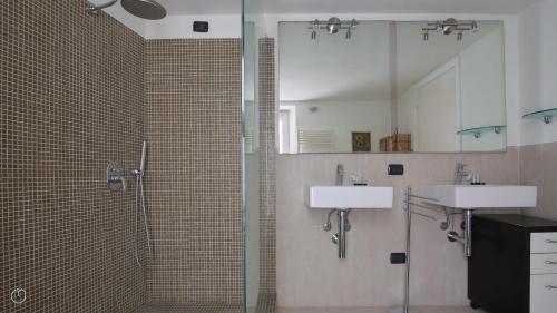 a bathroom with two sinks and a glass shower at Italianway - Riva Soldino 9 in Laglio