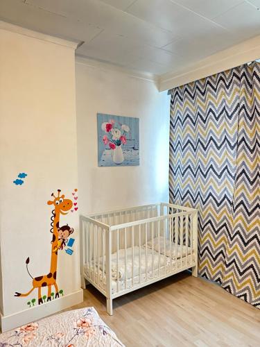 Habitación infantil con pared estampada de jirafa en Big Sunset 3 Bedroom House with a Garden, en Amberes