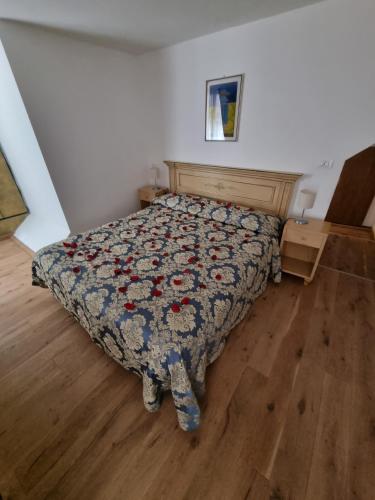 a bedroom with a bed with a floral bedspread at Albergo Casa Peron in Venice