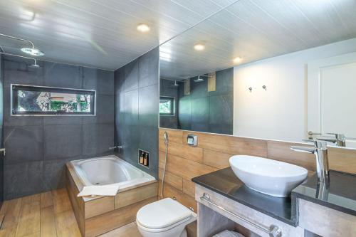 a bathroom with a sink and a toilet and a tub at Laurentino Loft & Home in Villa General Belgrano