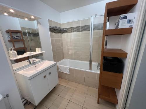 een badkamer met een bad, een wastafel en een douche bij Les jardins de Disney in Ferrières-en-Brie