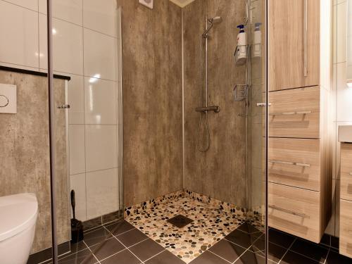 a bathroom with a shower with a toilet and a sink at Perfekt base for det meste! in Leknes
