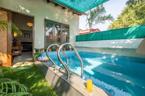a swimming pool next to a house at Nyara Fontainhas Panaji - Heritage villa Goa in Panaji