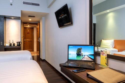a hotel room with a laptop computer on a desk at The Hills Batam in Nagoya