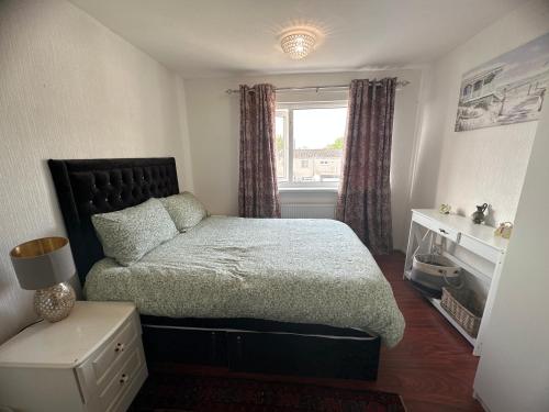 ein kleines Schlafzimmer mit einem Bett und einem Fenster in der Unterkunft Charming house welcome in Cardiff
