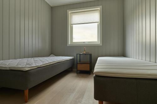a bedroom with two beds and a window at Perfekt base for det meste! in Leknes