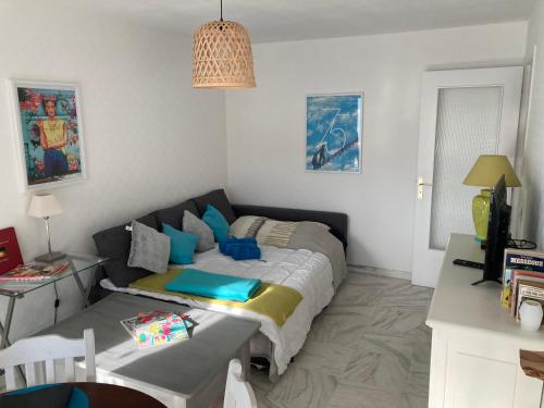 een slaapkamer met een bed en een tafel. bij Appart proche plage avec grand balcon in Cannes