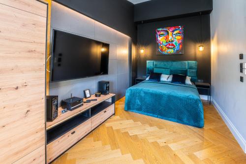 a bedroom with a bed and a large television at Oliwa Am Calsberg 5a in Gdańsk