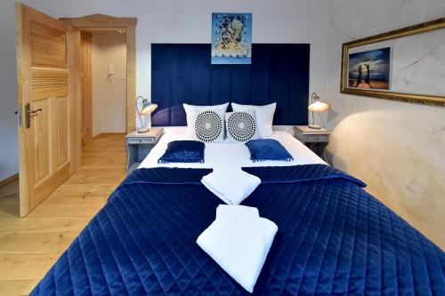 a large blue and white bed in a room at Dali Aparthotel in Koszalin