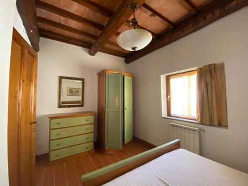 1 dormitorio con armario verde y ventana en Alloggio Laura in Residence Maremma en Castel del Piano