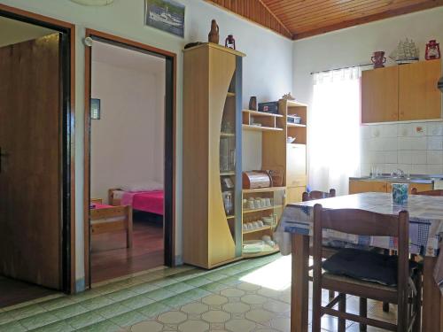 eine Küche mit einem Tisch und ein Zimmer mit einem Schlafzimmer in der Unterkunft CAPTAIN'S Holiday HOUSE in Žirje