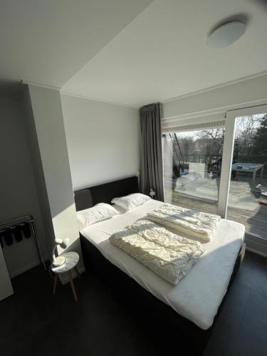 a bedroom with a large bed and a large window at Residence het Centrum in Oostkapelle