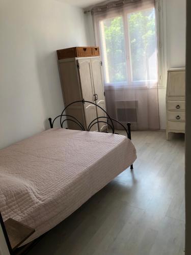 une chambre avec un lit, une commode et une fenêtre dans l'établissement Lo pequelet, à Avignon