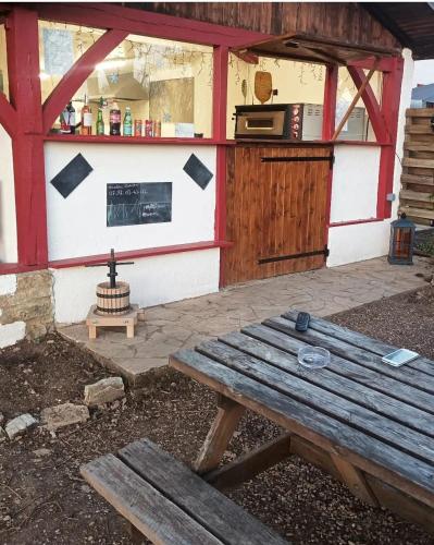 une table de pique-nique en bois devant un bâtiment dans l'établissement Emplacement tente camping car, à Saint-Aubin-de-Nabirat