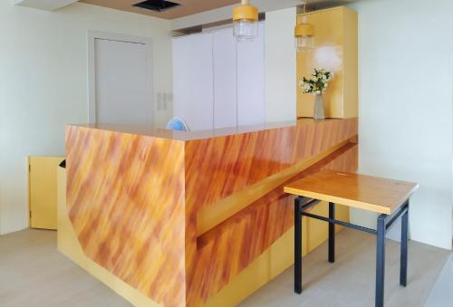a kitchen with a wooden counter and a wooden table at RedDoorz @ Benelio Suites Pavia Iloilo in Pavia