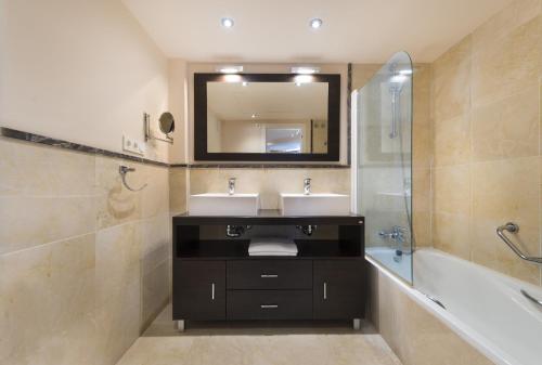 a bathroom with two sinks and a tub and a mirror at Apartamento de 2 dormitorios en Torrox Costa in Torrox Costa