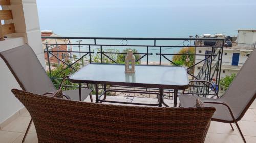 a table on a balcony with a view of the ocean at Rozos House in Loutsa