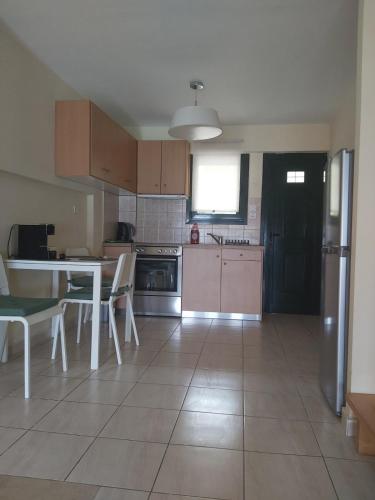 a kitchen with a table and chairs and a table and a kitchen with aearcher at Rozos House in Loutsa