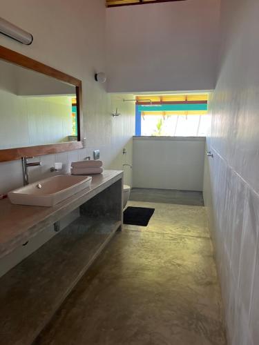 米瑞莎的住宿－Atulya Lake View - Resort and Spa，一间带水槽和镜子的浴室