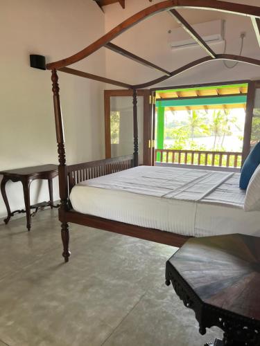 um quarto com uma cama grande e uma janela em Atulya Lake View - Resort and Spa em Mirissa