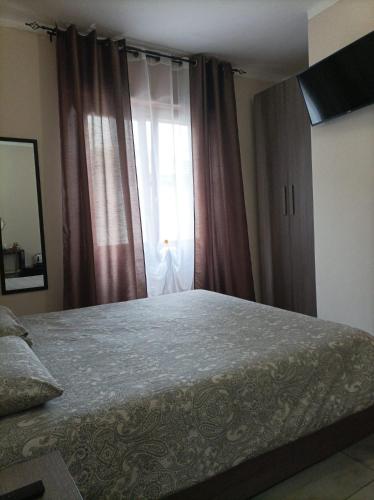 een slaapkamer met een groot bed en een raam bij B&B Perbaccobar in Ono San Pietro