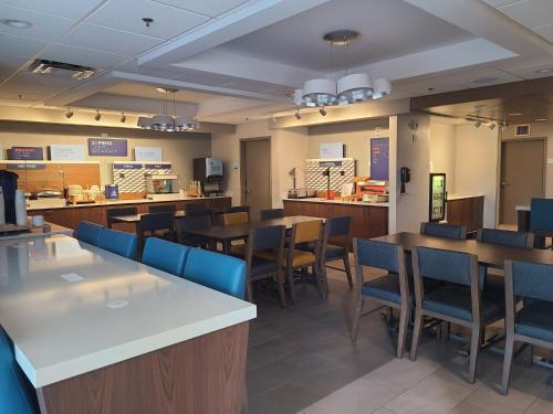 uma sala de jantar com mesas e cadeiras azuis em Holiday Inn Express Fort Lauderdale North - Executive Airport, an IHG Hotel em Fort Lauderdale