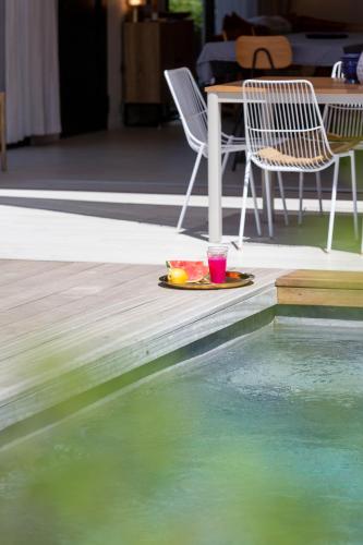 a plate of food sitting on a deck next to a pool at Villas les Capucines in Sète