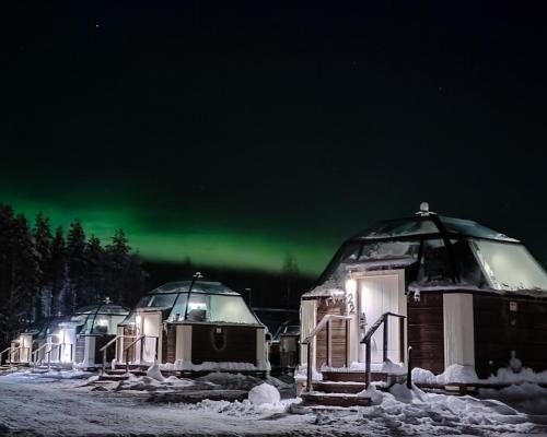a group of domes with the aurora in the sky at Arctic SnowHotel & Glass Igloos in Sinettä
