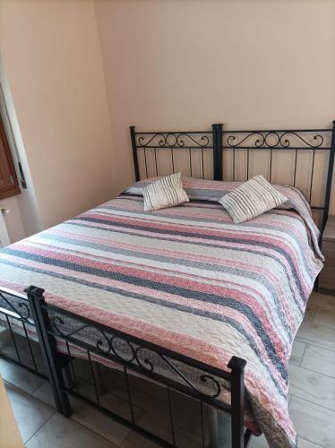 een bed met een gestreepte deken erop bij B&B Perbaccobar in Ono San Pietro