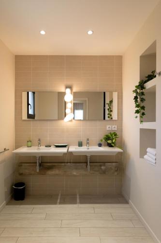 a bathroom with two sinks and a mirror at Villas les Capucines in Sète