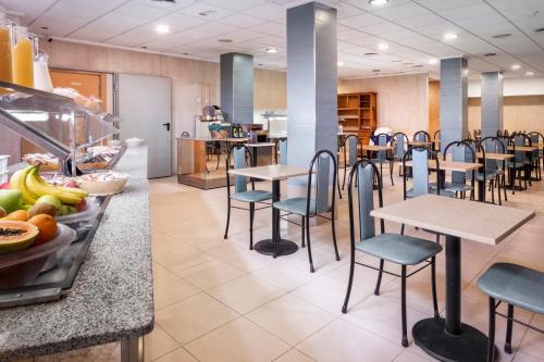 ein Restaurant mit Tischen und Stühlen und einer Theke mit Speisen in der Unterkunft Hotel Andalucía in Benidorm