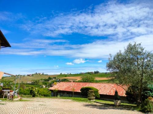 Cascina Cantaret Agriturismo في اجليانو تيرمي: منزل بسقف احمر وممر من الطوب