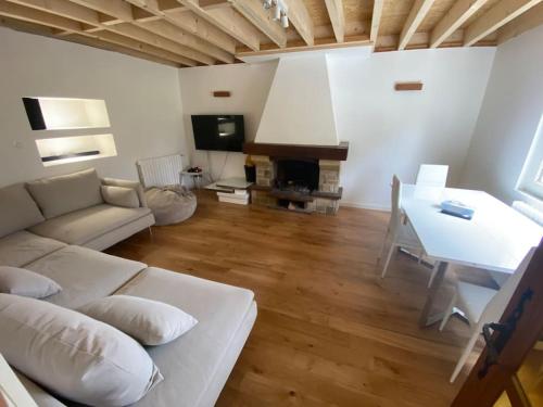 un salon avec un canapé blanc et une table dans l'établissement Charmante maison au coeur de la nature, à Cany-Barville