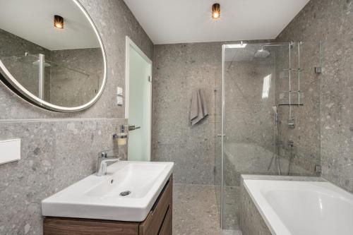 a bathroom with a sink and a shower and a tub at Lubminer Meerblick Apartments in Lubmin