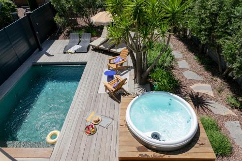 a bath tub sitting on a wooden deck next to a swimming pool at Villas les Capucines in Sète